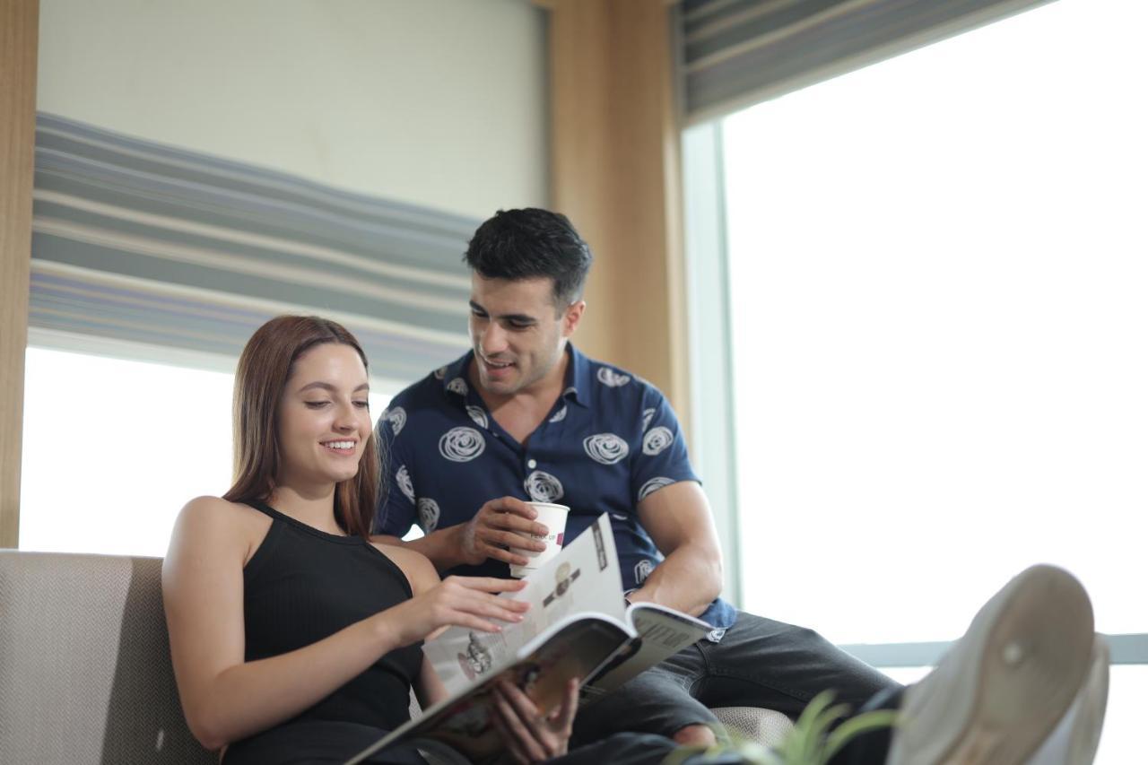 Aloft New Delhi Aerocity Ngoại thất bức ảnh A couple reading a magazine